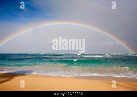 Der Regenbogen überspannt die Meereswellen am Baldwin Beach an der Nordküste von Maui bei Paia; Maui, Hawaii, Vereinigte Staaten von Amerika Stockfoto
