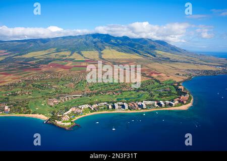 Luftüberblick über die Küste von West Maui und die Kaanapali Beach Gegend mit Hotels und Ferienwohnungen entlang der Küste und den West Maui Mountains ... Stockfoto