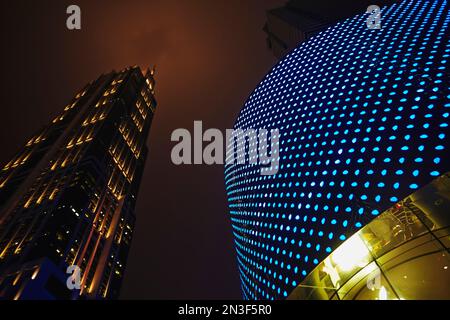 Nahaufnahme von Gebäuden mit Lichtern vor dem Hong Kong Plaza in der Nähe von Xintiandi; Shanghai, China Stockfoto