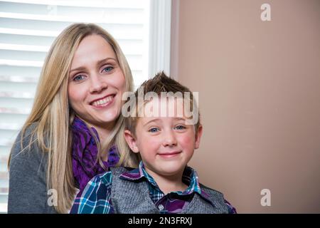 Porträt einer jungen behinderten Mutter mit Sohn, der zu Hause auf ihrem Schoß sitzt; Spruce Grove, Alberta, Kanada Stockfoto