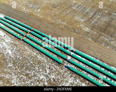 Luftaufnahme des Rohrleitungsbaus auf einem schneebedeckten Feld westlich von Calgary in Alberta, Kanada Stockfoto