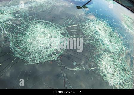 Schwere Hagelschäden an der Windschutzscheibe eines geparkten Autos; Blair, Nebraska, Vereinigte Staaten von Amerika Stockfoto