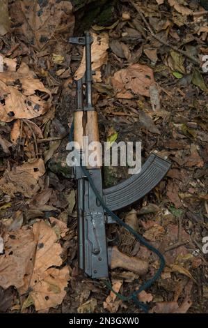 Maschinengewehr, das in Laubstreu auf dem Boden liegt und einer Garde des Nationalparks im Queen Elizabeth National Park, Uganda, Afrika, gehört Stockfoto