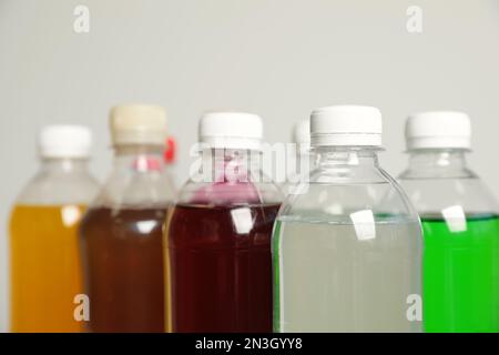 Flaschen mit alkoholfreien Getränken auf grauem Hintergrund, Nahaufnahme Stockfoto