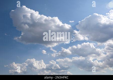 Wolken, die im Sonnenlicht vor einem blauen Himmel leuchten; Burwell, Nebraska, Vereinigte Staaten von Amerika Stockfoto