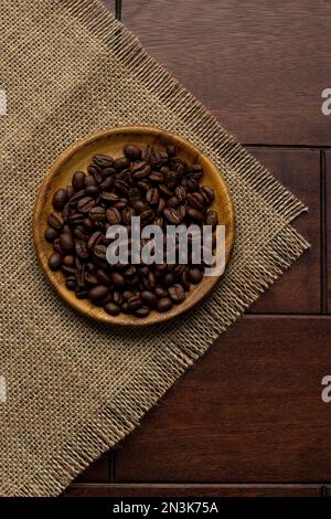 Kaffeebohnen auf Holzteller - frische Kaffeebohnen Stockfoto