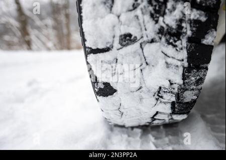 Nahaufnahme eines Winter-Geländewagens auf einer schneebedeckten Straße. Stockfoto