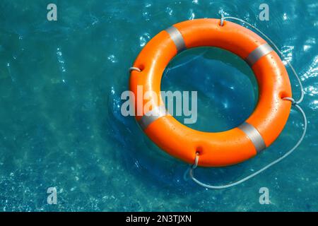 Orangefarbene Rettungsboje, schwimmend im Meer, über der Aussicht. Rettungsausrüstung Stockfoto