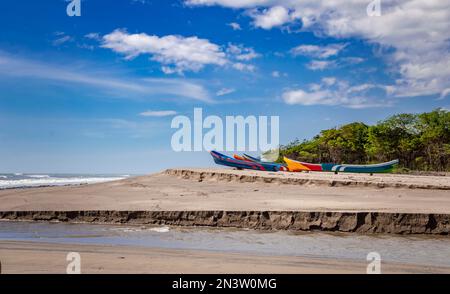 Vier Boote parken am Sand, Fischerboote parken in der Nähe des Ozeans, Boote, die am Meer mit blauem Himmel gestrandet sind Stockfoto