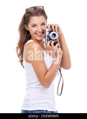 Sagen Sie Cheese. Eine junge Frau, die eine Kamera vor weißem Hintergrund hält. Stockfoto