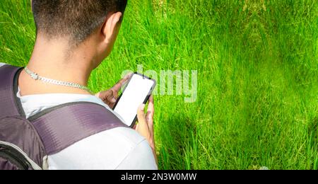 Nahaufnahme eines Mannes mit Handy in der Hand, Nahaufnahme einer Person, die sein Handy überprüft, junger Mann mit Handy in der Hand und Kopierraum Stockfoto