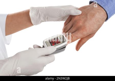 Arzt überprüft Sauerstoffgehalt des Patienten mit Pulsoxymeter auf weißem Hintergrund, Nahaufnahme Stockfoto