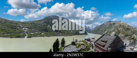 Grimselsee und historisches Alpine Hotel Grimsel Hospiz vor den Bergen Vorderer Zinggenstock, Hinterer Zinggenstock, Finsteraarhorn und Stockfoto