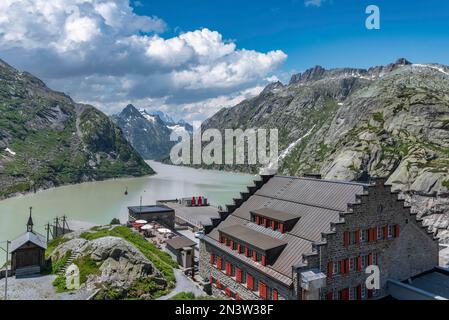 Grimselsee und historisches Alpine Hotel Grimsel Hospiz vor den Bergen Vorderer Zinggenstock, Hinterer Zinggenstock, Finsteraarhorn und Stockfoto