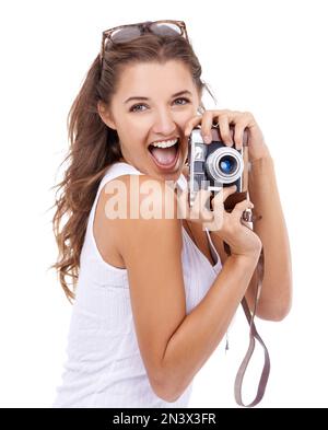 Sagen Sie Cheese. Eine junge Frau, die eine Kamera vor weißem Hintergrund hält. Stockfoto