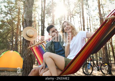 Ein Paar, das sich am Sommertag in einer Hängematte im Freien ausruht Stockfoto