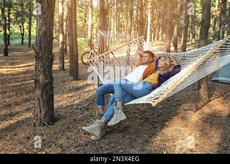 Glückliches Paar, das sich an einem Sommertag in einer Hängematte im Freien ausruht Stockfoto