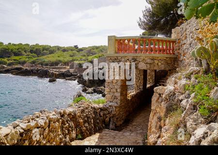 Bogen eines privaten Grundstücks auf dem gepflasterten Pfad entlang der Küste am Rand der Wände der luxuriösen Villen Juan-les-Pins in Antibes Frankreich Stockfoto