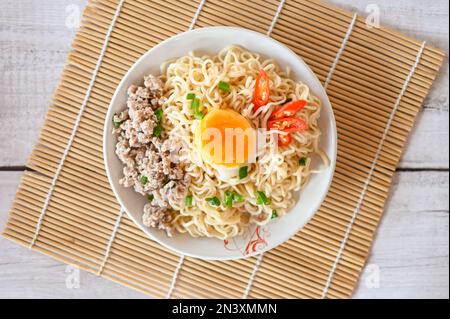 Nudelteller mit Eierhackfleisch, Gemüse, Zwiebelsellerie und Chili auf dem Tisch, Instant-Nudeln, leckeres Essen mit Schüssel, Nudeln - Top Stockfoto