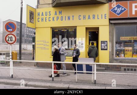 Die Berliner Mauer. Eine bewachte Betonbarriere, die Westberlin von 1961 bis 1989 umkreiste und es von Ostberlin und Ostdeutschland trennte. Der Bau der Berliner Mauer begann 1961. Westberlin war eine politische Enklave, die den westlichen Teil Berlins während der Jahre des Kalten Krieges umfasste. Foto 1978 der Berliner Mauer und ihrer Betonbauteile, die links sichtbar sind, mit Schwerpunkt auf der Ausstellung Haus am Checkpoint Charlie. Stockfoto