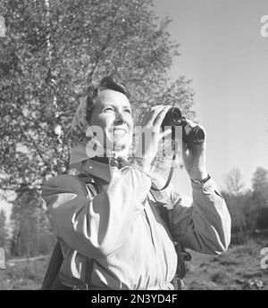 1940er Outdoor-Leben. Eine Frau ist in der Natur und interessiert sich für Natur und Vögel. Sie trägt die typische 1940er-Art von Outdoor-Kleidung mit sportlichem Charakter, die praktisch und strapazierfähig ist. Sie benutzt ein Fernglas, um etwas besser zu sehen. Schweden 1949. Foto Kristoffersson Ref. AR29-5 Stockfoto