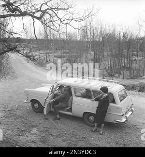 Fahren in der 1960er. Eine Frau steht neben einem Auto Opel Olympia und spricht mit dem Mann auf dem Fahrersitz, der die Vordertür geöffnet hat. Schweden 1961 Kristoffersson Ref CT49-9 Stockfoto