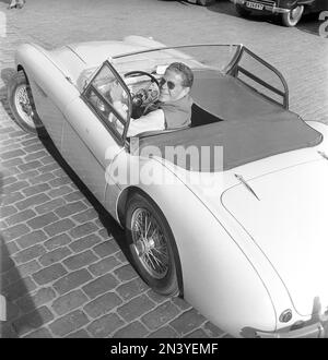 Fahren in der 1950er. Schauspieler Sture Lagerwall in seinem britischen Austin-Healey 100-6, einem Cabrio. Schweden 1953. ref. BL108-9 Stockfoto