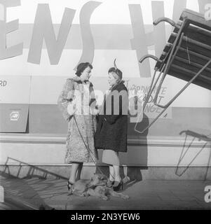 Damenmode in den 1940er. Zwei Frauen stehen sich nahe und reden über etwas. Sie tragen warme Mäntel und passende Hüte. Schweden 1949 Kristoffersson Ref AT37-11 Stockfoto
