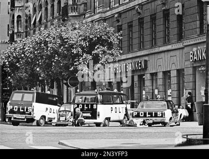 Der Norrmalmstorg-Raub am 23-28. august 1973. Kreditbanken auf der Normmalmstorg in Stockholm. Das erste kriminelle Ereignis in Schweden, über das live im Fernsehen berichtet wurde. Jan-Erik Olsson war der Räuber und wurde von einem ehemaligen Zellengenossen und Freund Clark Olofsson in der Bank begleitet. Die Räuber gaben auf, nachdem die Polizei Tränengas benutzte, keiner der Geiseln wurde verletzt. Ein Banküberfall und eine Geiselnahme, am besten bekannt als der Ursprung des Wortes Stockholm-Syndrom, ein vorgeschlagener Zustand, in dem Geiseln eine physologische Bindung zu ihren Entführern entwickeln. Das Bild zeigt die Polizeiautos vor der Bank, Ford, Volkswa Stockfoto