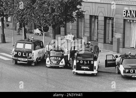 Der Norrmalmstorg-Raub am 23-28. august 1973. Kreditbanken auf der Normmalmstorg in Stockholm. Das erste kriminelle Ereignis in Schweden, über das live im Fernsehen berichtet wurde. Jan-Erik Olsson war der Räuber und wurde von einem ehemaligen Zellengenossen und Freund Clark Olofsson in der Bank begleitet. Die Räuber gaben auf, nachdem die Polizei Tränengas benutzte, keiner der Geiseln wurde verletzt. Ein Banküberfall und eine Geiselnahme, am besten bekannt als der Ursprung des Wortes Stockholm-Syndrom, ein vorgeschlagener Zustand, in dem Geiseln eine physologische Bindung zu ihren Entführern entwickeln. Das Bild zeigt die Polizeiautos vor der Bank, Ford, Volkswa Stockfoto