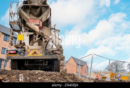 Halbtrockener Fertigbeton, der auf der Baustelle geliefert und von der Baustelle abgeführt wird Den Mischwagen Stockfoto