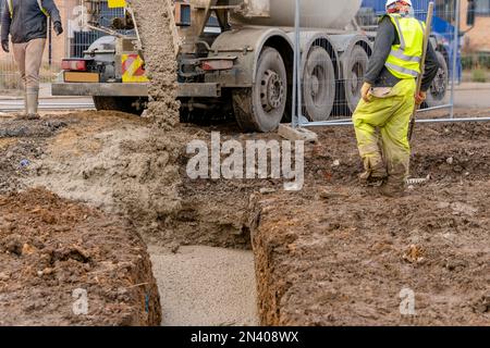 Halbtrockener Fertigbeton, der auf der Baustelle geliefert und von der Baustelle abgeführt wird Den Mischwagen Stockfoto