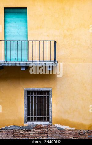 Eine türkisfarbene Balkontür und ein verschließtes Fenster mit Blick auf einen der Kanäle in Venedig. Stockfoto