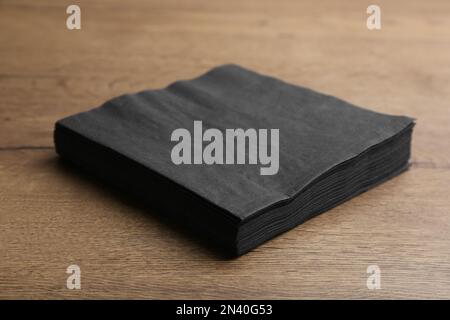 Stapel schwarzer sauberer Papiertücher auf Holztisch Stockfoto