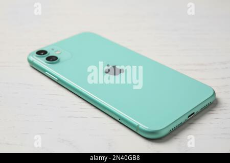 MYKOLAIV, UKRAINE - 10. JULI 2020: Neues modernes iPhone 11 Grün auf weißem Holztisch Stockfoto