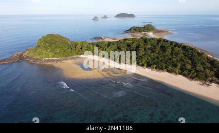 Luftaufnahme einer tropischen Insel mit Palmen und anderen kleinen Inseln im Hintergrund Stockfoto