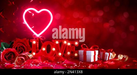 Valentinstag - Red Love Text with Love Dekoration with Gift and Roses in Abstract Unschärfe Background Stockfoto