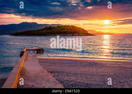 Unglaubliche Meereslandschaft des Ionischen Meeres mit der Insel Korfu im Hintergrund. Herrlicher Frühlingsblick auf das Dorf Ksamil. Dramatische Outdoor-Szene in Albanien, Europa. Stockfoto