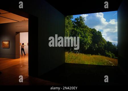 A video image of a landscape is projected as people wander around an exhibition entitled: 'Constable: The Making of a Master ' with works by British landscape painter John Constable, during a preview at the Victoria and Albert Museum, in London, Wednesday, Sept. 17, 2014. Best-known to many for ‘The Hay Wain’ - an artwork which adorns countless decorative plates and trays, the exhibition explores Constable’s influences and takes a look at the creative process behind some of his most famous works. The exhibition will run from Sept. 20, 2014 to Jan. 11. 2015.(AP Photo/Lefteris Pitarakis)