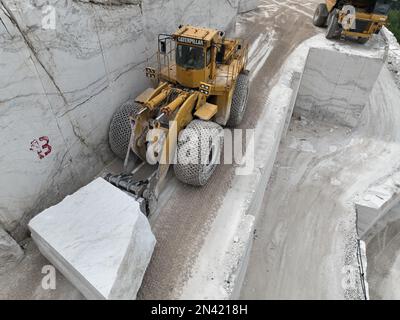 Radlader, die an riesigen Marmorsteinbrüchen arbeiten. Stockfoto