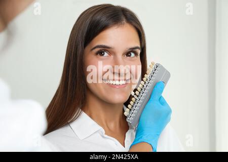 Arztprüfung der Zahnfarbe junger Frauen in der Klinik. Kosmetische Zahnheilkunde Stockfoto