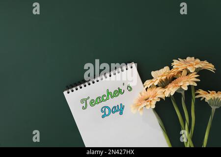 Notizbuch mit Phrase Teacher's Day und wunderschönen Blumen auf grüner Tafel, flach liegend. Platz für Text Stockfoto