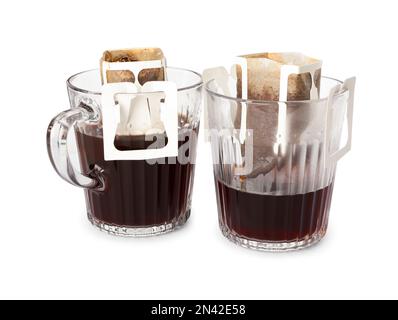 Glasbecher mit Kaffeebeuteln, isoliert auf weiß Stockfoto