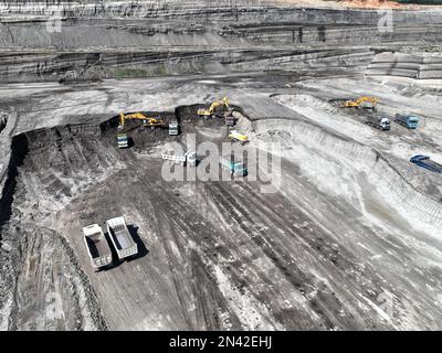 Bagger in Betrieb. Lade Lastwagen auf eine riesige Bergbaustelle. Stockfoto