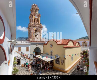 SYMI, GRIECHENLAND - September 6,2015: Besucher des Klosters Erzengel Michael Panormitis auf der malerischen Insel Symi, Dodekanese, Griechenland Stockfoto