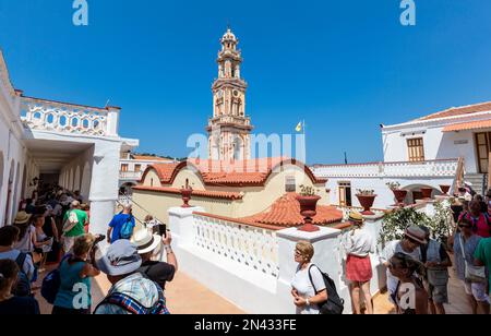 SYMI, GRIECHENLAND - September 6,2015: Besucher des Klosters Erzengel Michael Panormitis auf der malerischen Insel Symi, Dodekanese, Griechenland Stockfoto