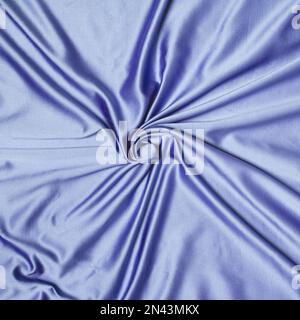 Abstrakter Hintergrund, Textur aus zerknitterter Seide in spirallila verdreht. Stockfoto