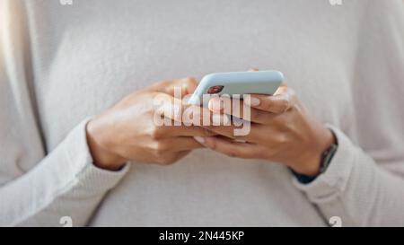 Person, die ein Telefon in der Hand hält, während sie in sozialen Medien SMS schreibt. Eine trendige Frau schreibt schnell und bequem eine Textnachricht über eine Instant Chat-App. Nahaufnahme von Stockfoto