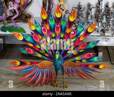 Ein Alebrije-Pfau in einem Kunsthandwerksladen in San Antonio Arrazola, Oaxaca, Mexiko. Alebrijes sind farbenfrohe, gemalte Kreaturen, die mit dem verwandt sind Stockfoto