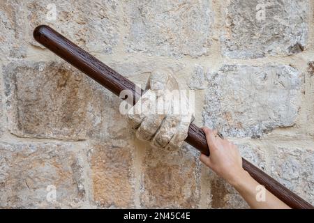 Eine Nahaufnahme einer Frauenhand, die das Geländer des Rektorenpalastes in Dubrovnik, Kroatien, hält. Stockfoto